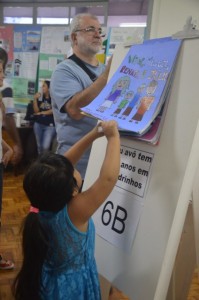 Estudante dos anos iniciais do Ensino Fundamental confere o trabalho dos colegas mais velhos.